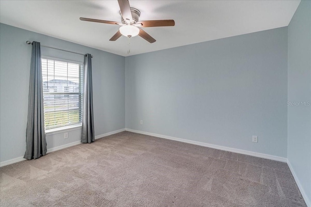 unfurnished room with ceiling fan, a wealth of natural light, and light colored carpet