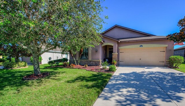 single story home with a garage and a front lawn