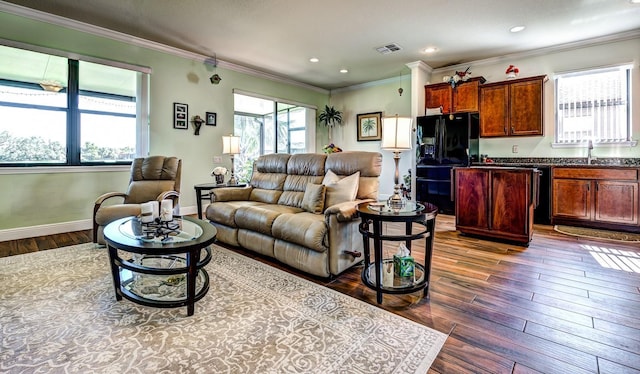 living room featuring dark hardwood / wood-style flooring, plenty of natural light, and ornamental molding