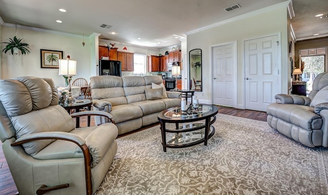 living room with ornamental molding and light hardwood / wood-style flooring