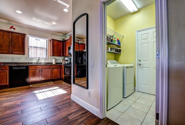 kitchen with black appliances, sink, washer and clothes dryer, light wood-type flooring, and ornamental molding