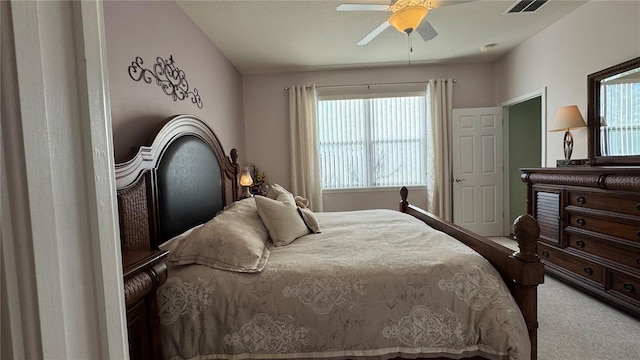 carpeted bedroom featuring a ceiling fan and visible vents