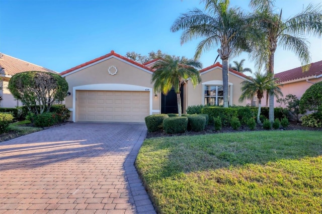 mediterranean / spanish home with a front lawn and a garage