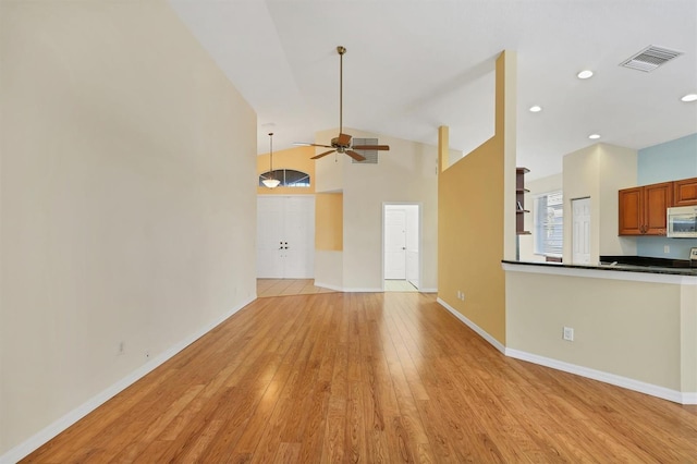 unfurnished living room featuring ceiling fan, high vaulted ceiling, and light hardwood / wood-style floors