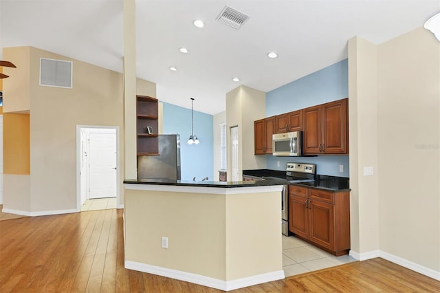 kitchen with kitchen peninsula, appliances with stainless steel finishes, light hardwood / wood-style floors, and pendant lighting