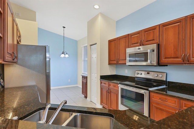 kitchen with sink, an inviting chandelier, pendant lighting, lofted ceiling, and appliances with stainless steel finishes