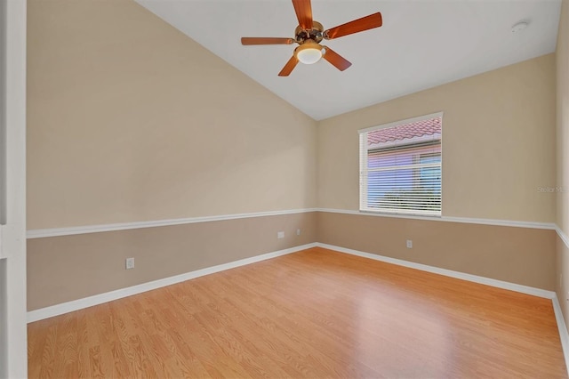 empty room with hardwood / wood-style flooring, ceiling fan, and vaulted ceiling