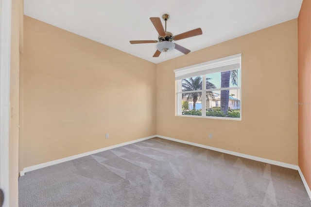 spare room featuring light colored carpet and ceiling fan