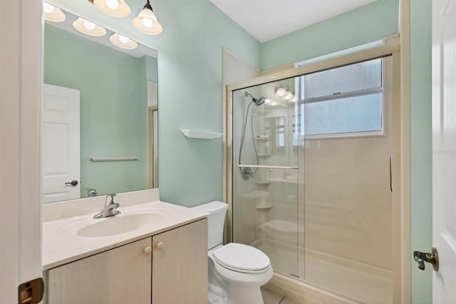 bathroom featuring vanity, toilet, and a shower with shower door