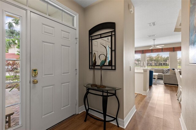 foyer entrance with ceiling fan, plenty of natural light, a textured ceiling, and light hardwood / wood-style flooring