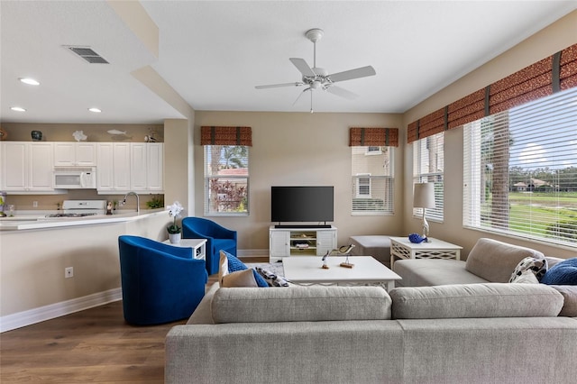 living room featuring sink, plenty of natural light, dark wood-type flooring, and ceiling fan