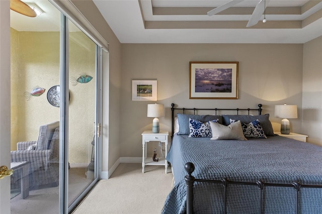 carpeted bedroom featuring ceiling fan and a tray ceiling