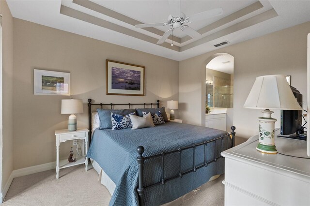 bedroom featuring a tray ceiling, ceiling fan, and light carpet