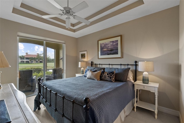 bedroom with carpet flooring, access to exterior, a raised ceiling, and ceiling fan