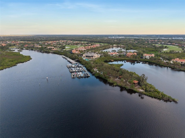 aerial view at dusk featuring a water view