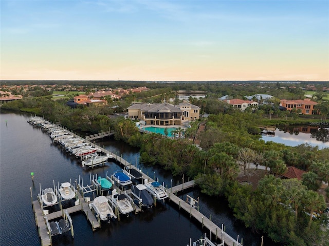 aerial view at dusk featuring a water view