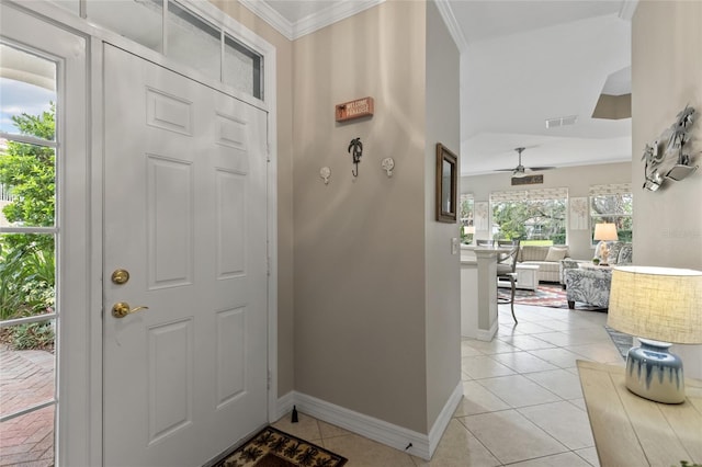 tiled entrance foyer featuring plenty of natural light, ceiling fan, and crown molding