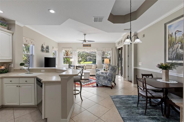 kitchen with white cabinets, decorative light fixtures, light tile patterned floors, and crown molding