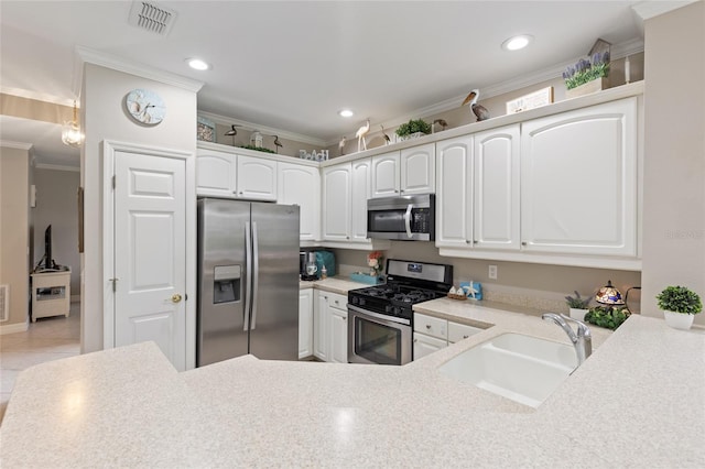 kitchen featuring sink, white cabinets, stainless steel appliances, and ornamental molding