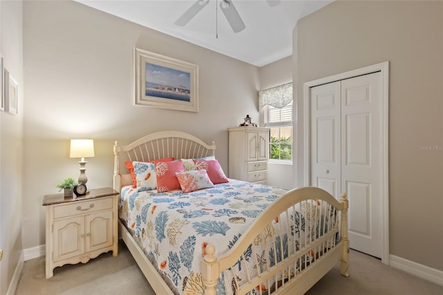 bedroom with ceiling fan, light carpet, and a closet