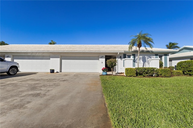 ranch-style house featuring a garage and a front lawn