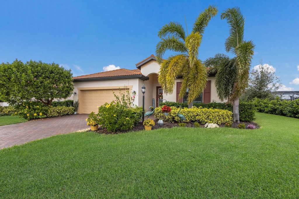 mediterranean / spanish home with a garage and a front lawn