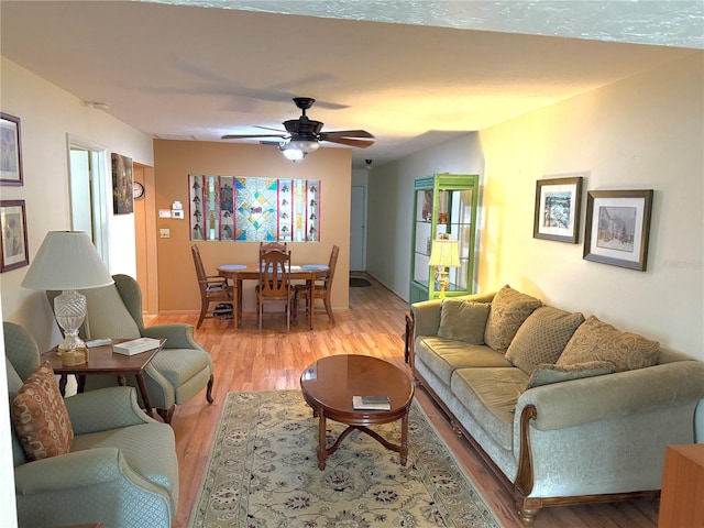 living room featuring ceiling fan and hardwood / wood-style floors