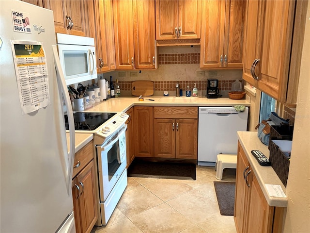 kitchen featuring light tile patterned floors, white appliances, and sink