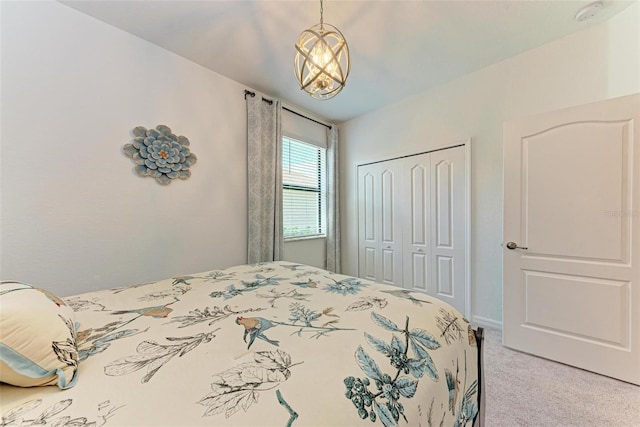 carpeted bedroom with a notable chandelier and a closet