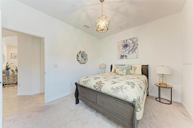 bedroom with light carpet and a chandelier