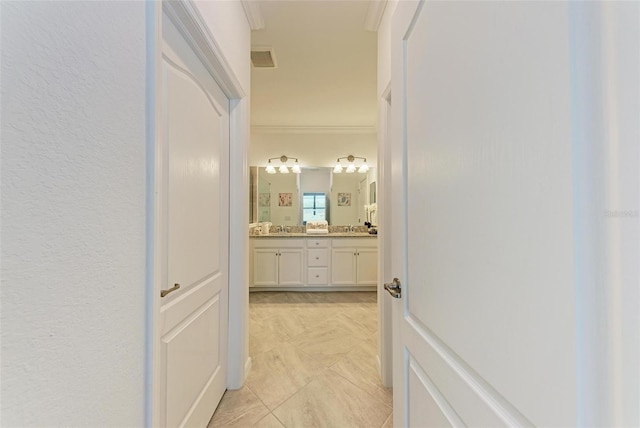 corridor featuring ornamental molding and sink