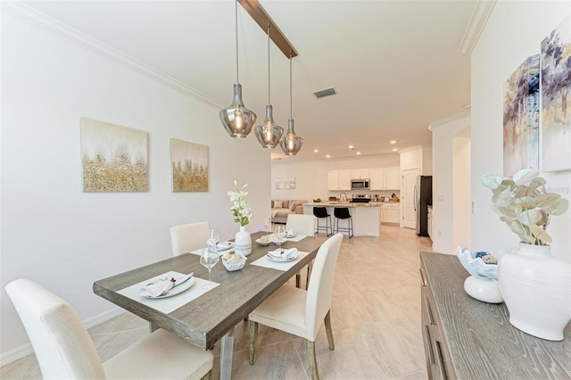 tiled dining room featuring crown molding