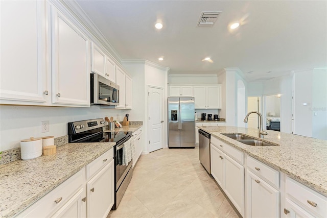 kitchen featuring light stone counters, stainless steel appliances, crown molding, sink, and white cabinets