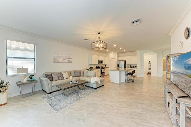 living room featuring a chandelier, light tile patterned floors, and ornamental molding