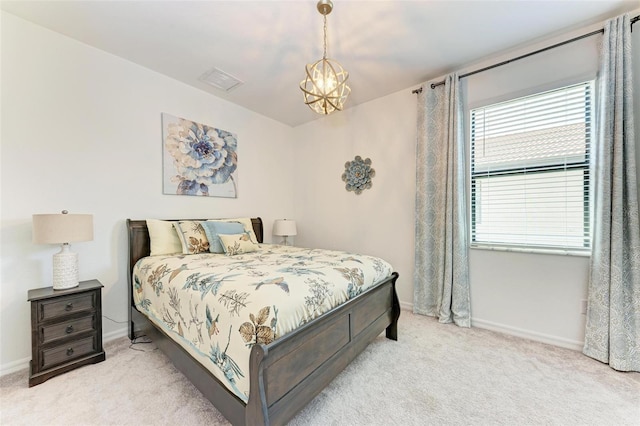 carpeted bedroom featuring an inviting chandelier