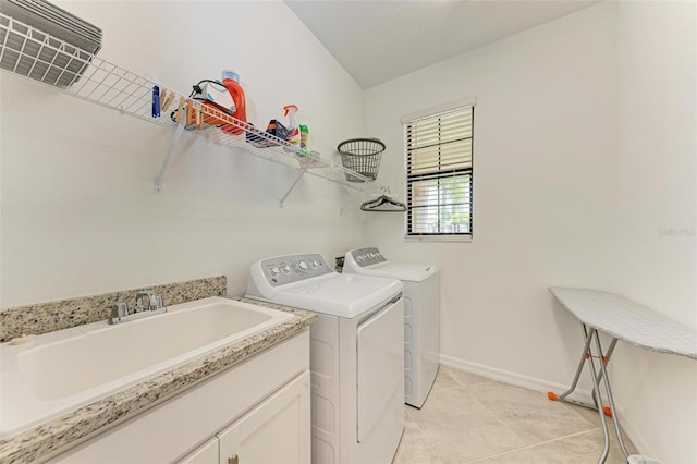 clothes washing area with light tile patterned flooring, sink, and washing machine and clothes dryer