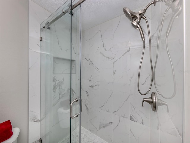 bathroom featuring a textured ceiling and an enclosed shower