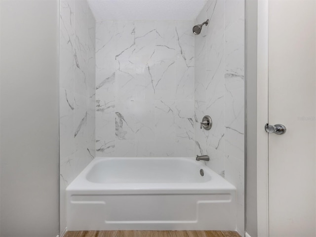 bathroom with tiled shower / bath combo and hardwood / wood-style floors