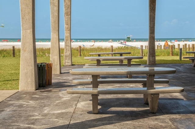 view of property's community featuring a water view and a beach view