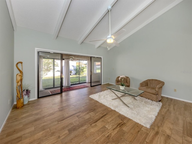 unfurnished room featuring ceiling fan, lofted ceiling with beams, and light wood-type flooring