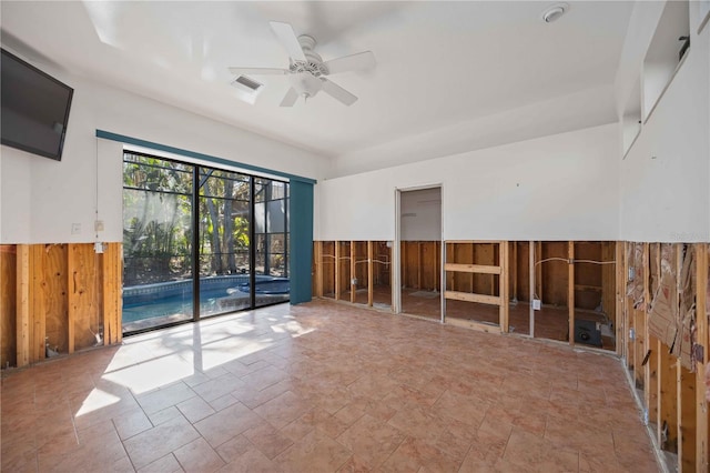 empty room with ceiling fan and wooden walls