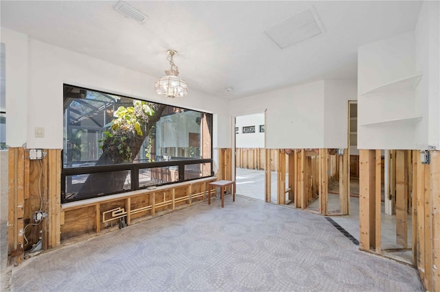 interior space with wood walls and a chandelier