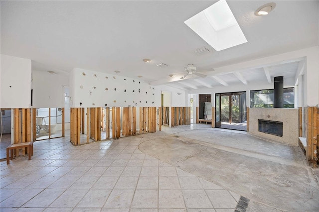 interior space with beam ceiling, a skylight, and ceiling fan