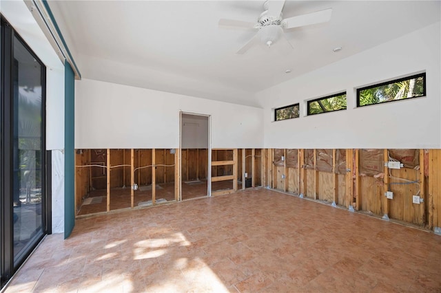 spare room with ceiling fan and wood walls