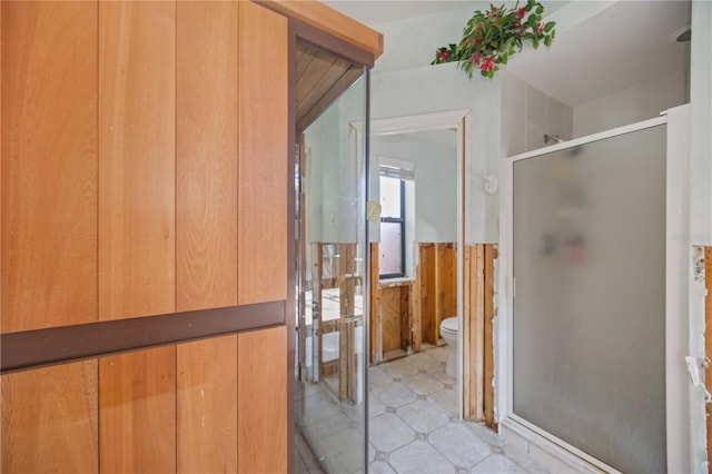 bathroom with toilet and a shower with door