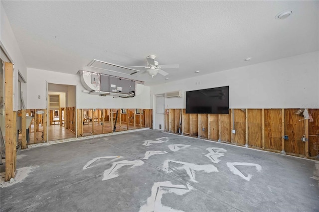 unfurnished living room featuring a wall mounted AC, wood walls, concrete floors, and a textured ceiling