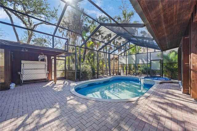 view of swimming pool featuring an in ground hot tub, a patio area, and a lanai