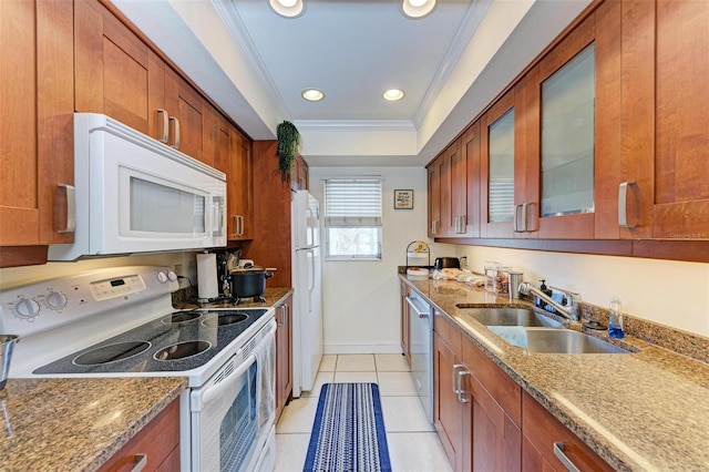 kitchen with light stone countertops, ornamental molding, white appliances, sink, and light tile patterned floors