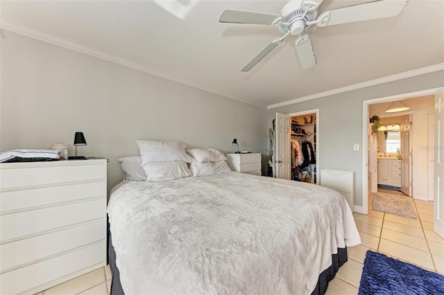 tiled bedroom featuring ceiling fan, a spacious closet, ornamental molding, and a closet