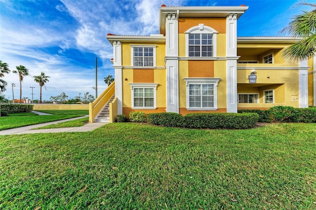 1195 Villagio Cir Unit 201, Sarasota, FL 34237 - rear view of house with stucco siding, a yard, and stairway